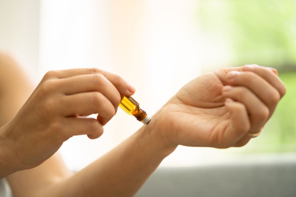 Applicazione di olio essenziale sul polso – esempio di uso sicuro dell'aromaterapia in ambiente domestico.