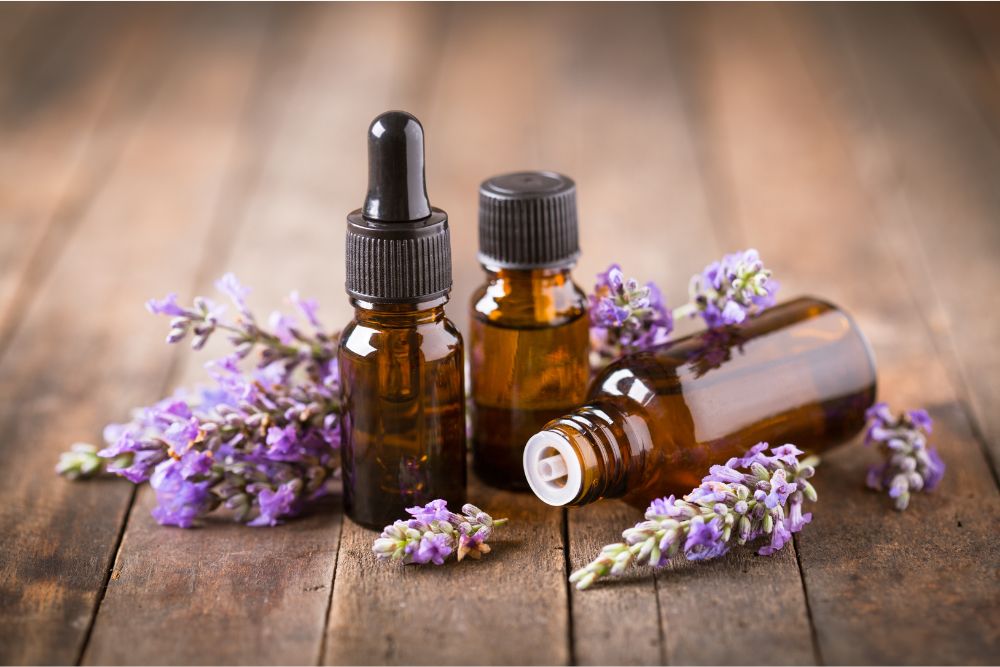 Flaconcini di olio essenziale di lavanda e fiori di lavanda su un tavolo di legno: cosmetica naturale.